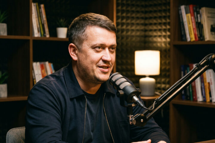 Евгений Зайферт кинокритик говорит в микрофон в студии подкаста